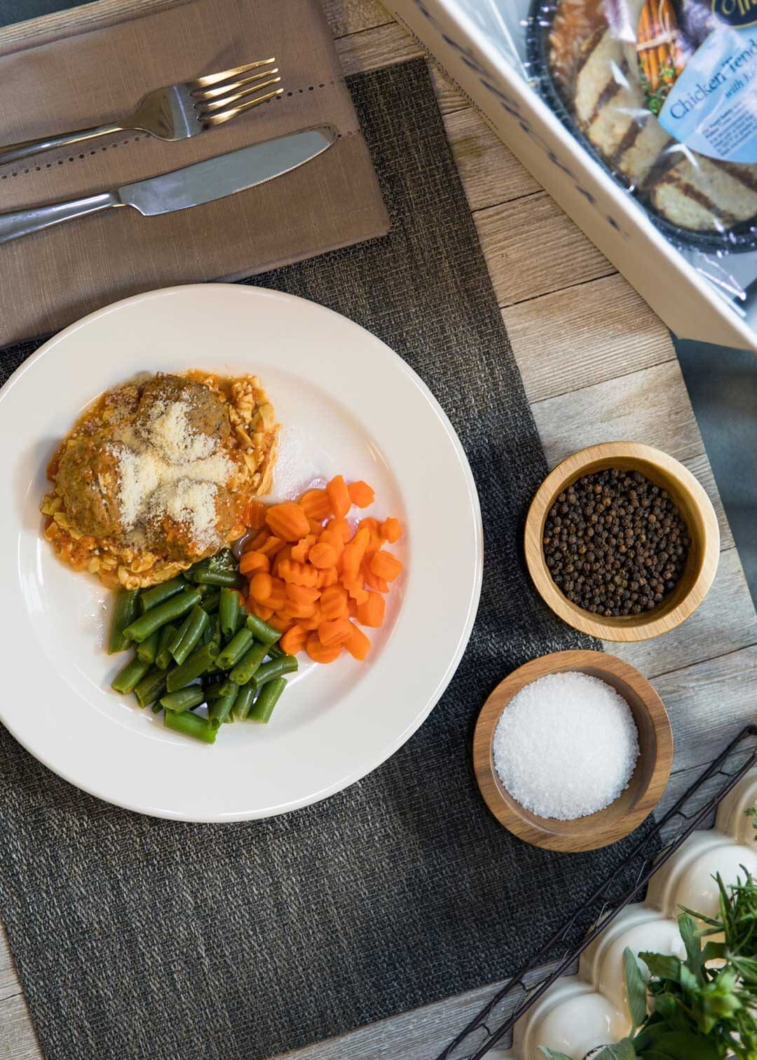 Overhead shot of plated Traditions Meal of meatballs, carrots and green beans