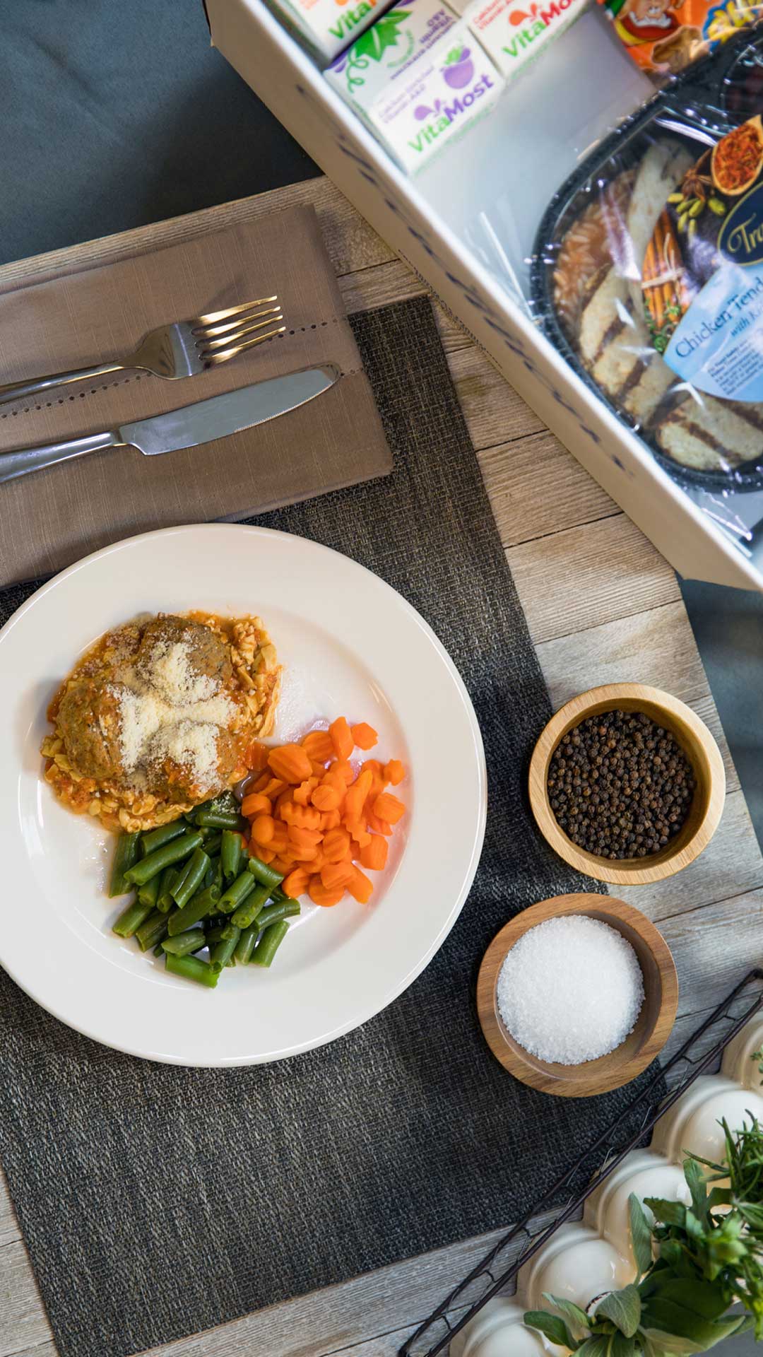 Overhead shot of plated Traditions Frozen Meals and variety box.