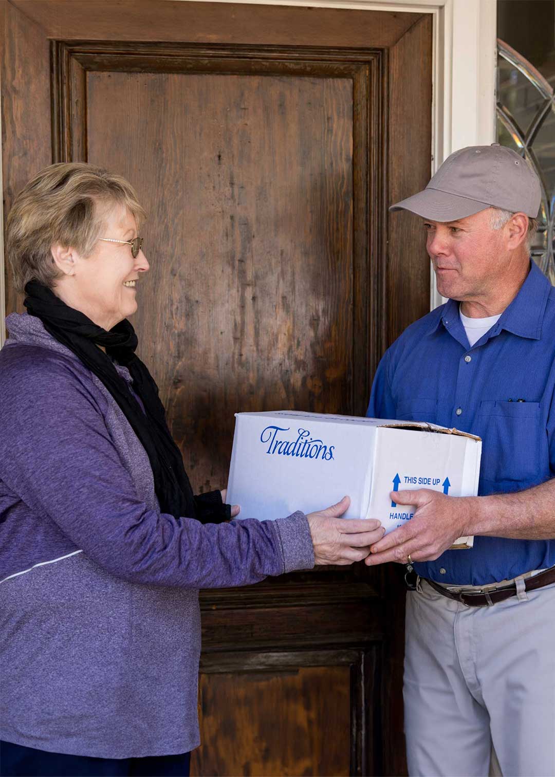 Traditions Frozen Meals delivery driver handing box to customer