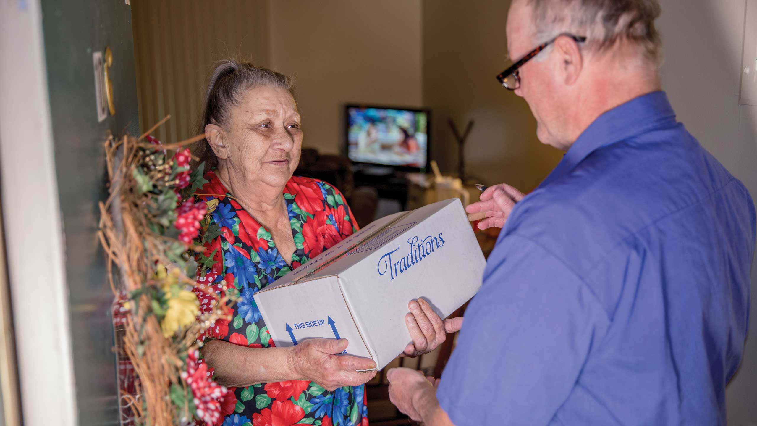 Traditions driver delivering box of frozen meals for Meals on Wheels